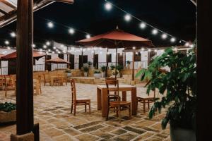 a restaurant with tables and chairs and umbrellas at Don Juan De Dios De Guane Hotel & Centro De Convenciones in Barichara