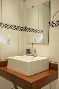 uma casa de banho com um lavatório branco e um espelho. em Pousada da Germana em Fernando de Noronha