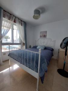 a bedroom with a bed and a large window at Lovely apartment in Torremolinos Views of the sea, pool, terrace, sofa bed and fully equipped kitchen in Torremolinos