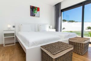 ein weißes Schlafzimmer mit einem großen Bett und einem Fenster in der Unterkunft Villa Videira By Dalma Portuguesa - By Dalma Portuguesa in Sesmarias + 57 Fotos