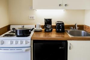 a kitchen with a stove and a sink at Ohia Waikiki Studio Suites in Honolulu