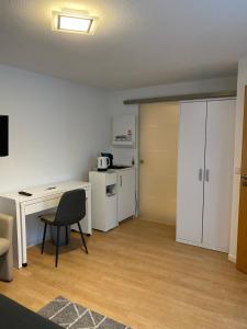 a room with a desk and a chair and a kitchen at Altstadt Apartment in Bamberg