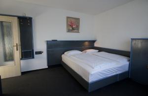 a bedroom with a large bed with a blue headboard at Hotel Merian in Cologne