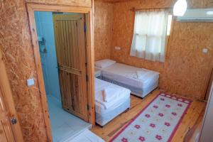 a small room with two beds and a window at Klas Rafting Pansiyon in Manavgat
