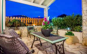 Villa Aelia - A Peaceful And Private Place في أرغوستولي: فناء مع طاولة وكراسي وسياج
