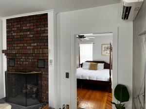 a room with a brick fireplace and a bedroom at Queen Anne's Revenge in Bar Harbor