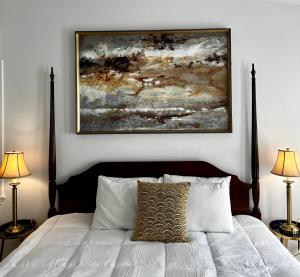 a bedroom with a bed with a painting above it at Queen Anne's Revenge in Bar Harbor