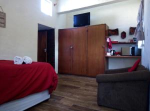 a bedroom with a bed and a chair and a cabinet at Sabi falls accommodation in Sabie