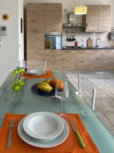 stół z talerzem owoców i kieliszkiem wina w obiekcie appartamento w mieście Porto Torres