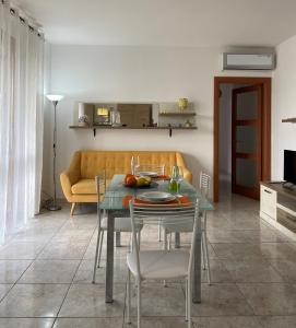 salon ze stołem i żółtą kanapą w obiekcie appartamento w mieście Porto Torres