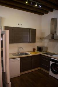 een keuken met bruine kasten en een wastafel bij El museo in Avila