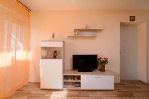 una sala de estar con TV y un centro de entretenimiento blanco en Ante Apartment, en Split