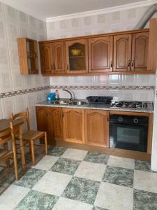 uma cozinha com armários de madeira, um lavatório e um fogão em El Rincon Del Duende em Vejer de la Frontera