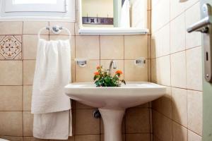 un baño con un lavabo con flores. en Villa Aelia - A Peaceful And Private Place en Argostoli