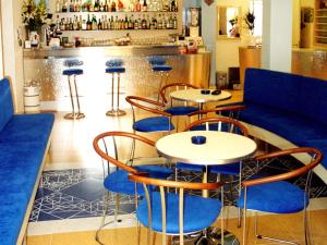 un restaurant avec des tables et des chaises bleues ainsi qu'un bar dans l'établissement Hotel Metron, à Cesenatico