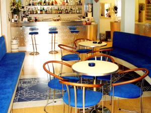 un ristorante con tavoli e sedie blu e un bar di Hotel Metron a Cesenatico