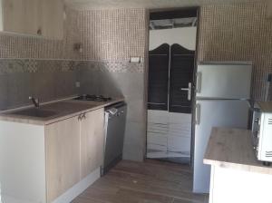 a kitchen with a sink and a refrigerator at L'Ancien Pressoir in Pierrefitte-en-Cinglais