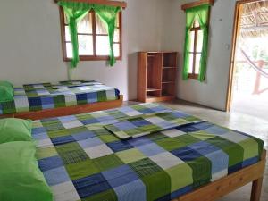 a bedroom with two beds and two windows at Bungalows Familiares in Monterrico