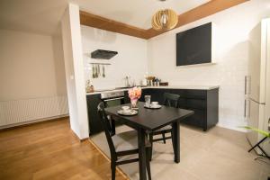 a kitchen with a black table and chairs in a room at SAND Apartment in Žilina