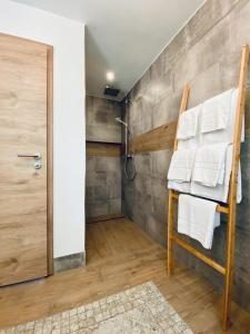 ein Badezimmer mit Dusche und einem Stuhl mit Handtüchern in der Unterkunft Grünberg House in Traben-Trarbach