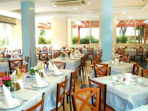 una sala da pranzo con tavoli e sedie con lenzuola bianche di Hotel Metron a Cesenatico