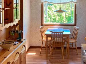 eine Küche mit einem Tisch und Stühlen sowie einem Fenster in der Unterkunft Holiday home BRASTAD V in Brastad