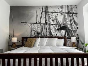 a bedroom with a large bed with a ship on the wall at Queen Anne's Revenge in Bar Harbor