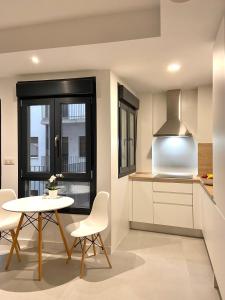 a kitchen with a table and chairs and a window at Cozy apartamento en distrito centro de Málaga in Málaga