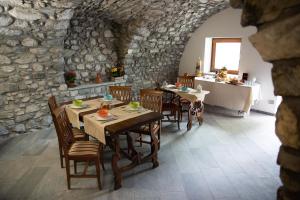 ein Esszimmer mit Tischen und Stühlen sowie eine Küche in der Unterkunft B&B LE AQUANE in Ono San Pietro