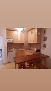 Belvedere luxury apartment في بانسكو: مطبخ بدولاب خشبي وطاولة خشبية