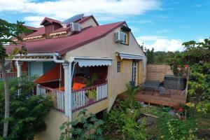 ein kleines Haus mit einer Veranda und einer Terrasse in der Unterkunft Le Saintois in Terre-de-Bas
