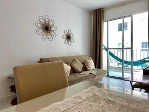 a living room with a couch and a large window at Ilha Madeira - Localização PRIVILEGIADA em frente à PRAIA in Ilhéus +15 photos