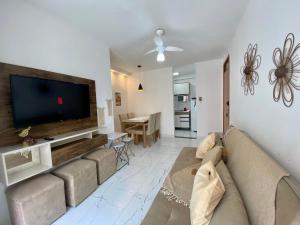 a living room with a couch and a flat screen tv at Ilha Madeira - Localização PRIVILEGIADA em frente à PRAIA in Ilhéus