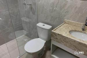 uma casa de banho com um WC, um lavatório e um chuveiro em Pel Apart Hotel em Pelotas