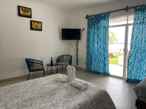 a hotel room with a bed with a swan on it at Departamentos Blue Bacalar in Bacalar