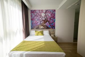 
a bedroom with a bed and a painting on the wall at Hotel Jardín de Bellver in Benicàssim
