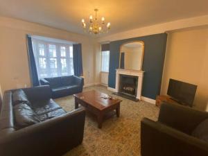 a living room with a couch and a fireplace at 8 Bedroom House For Corporate Stays in Kettering in Kettering