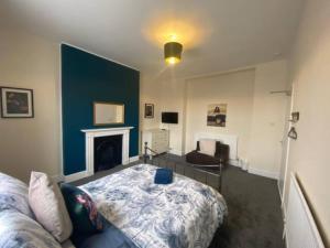 a living room with a bed and a fireplace at 8 Bedroom House For Corporate Stays in Kettering in Kettering