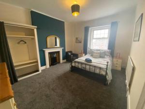 a bedroom with a bed and a fireplace at 8 Bedroom House For Corporate Stays in Kettering in Kettering +14 photos