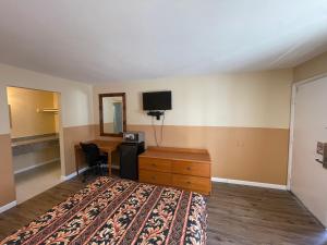 a hotel room with a bed and a desk and a tv at Sea Palace Motel in Seaside Heights