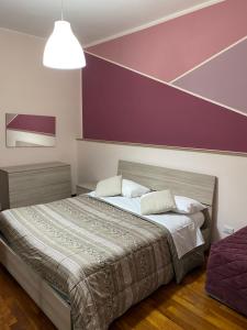 エルコラーノにあるB&b Il miglio d’oroの紫の壁のベッドルーム1室(ベッド1台付)