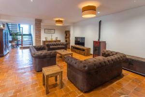 sala de estar con sofás de cuero y TV en Casa Rural Llanes Asturias, en Llanes