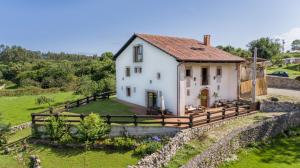 una casa en una colina con una valla en Casa Rural Llanes Asturias, en Llanes