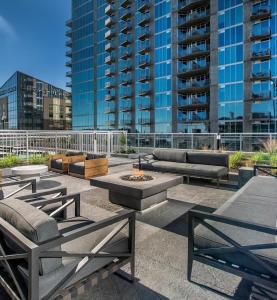 a patio with benches and a fire pit with buildings at Placemakr Premier SoBro in Nashville