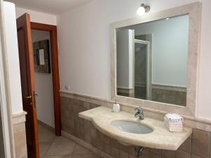 un baño con lavabo y espejo en CASA VACANZA MARYAM, en Pula 19 fotos más