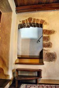 a room with a stone wall with a mirror at Casa Castori in Macomer
