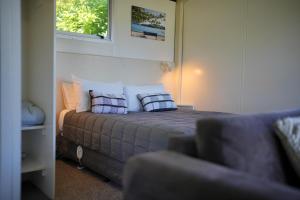 a bedroom with a bed with two pillows on it at Akaroa Top 10 Holiday Park in Akaroa