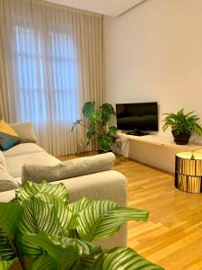 a living room with a couch and a flat screen tv at Habitación privada en Bilbao Centro in Bilbao