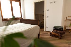 ein Schlafzimmer mit einem Bett und ein Zimmer mit Gepäck in der Unterkunft B&B LE AQUANE in Ono San Pietro
