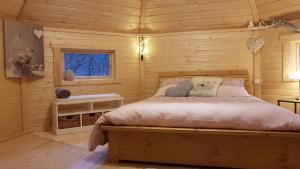 1 dormitorio con 1 cama en una cabaña de madera en NatureZenKota, en Mittlach